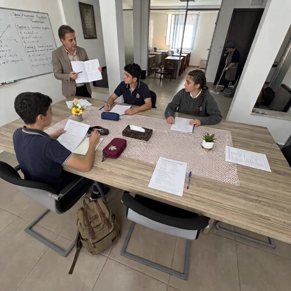 Un enseignant explique un exercice à un petit groupe de lycéens autour d'une table