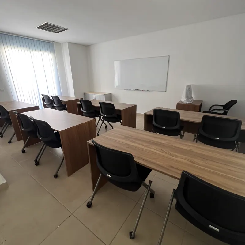 Salle de classe équipée de bureaux individuels et d'un tableau blanc